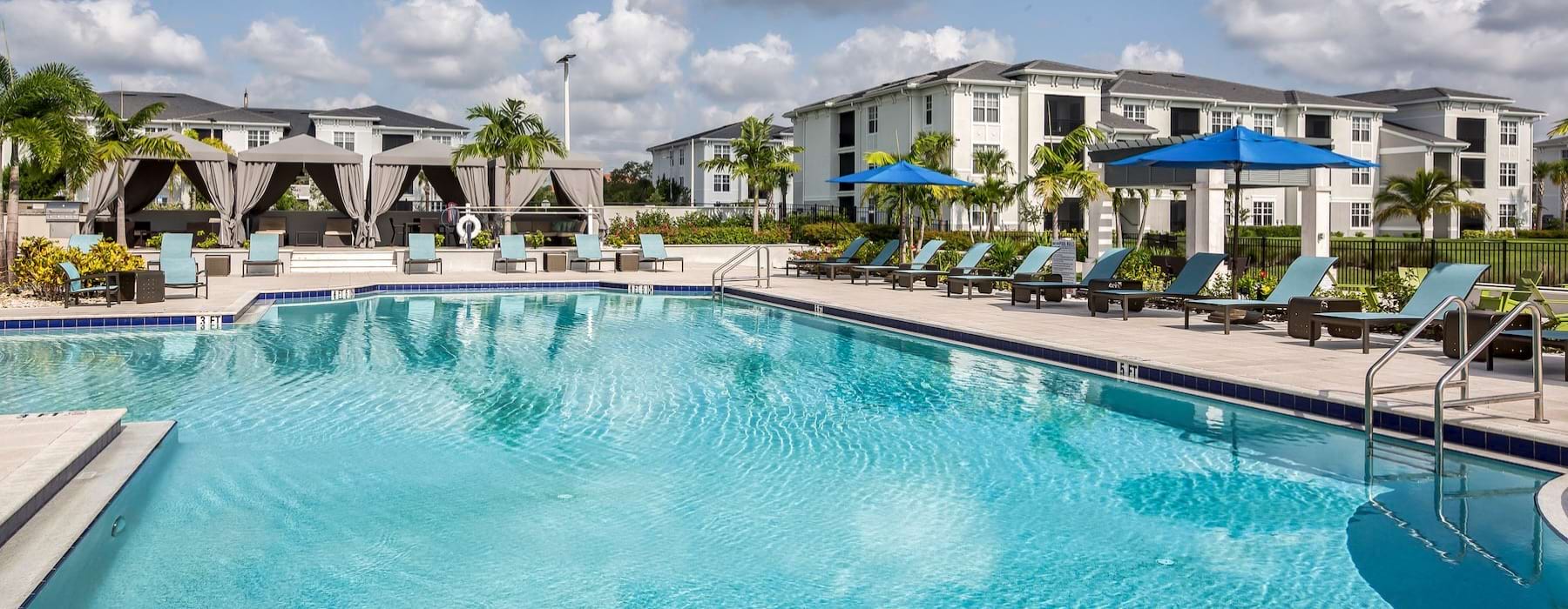 a swimming pool with chairs and umbrellas